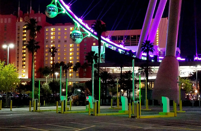 Parking automation with barriers and pay stations, ferris wheel in the background.